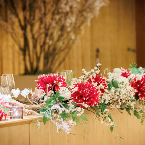 おふたりの披露宴会場「グレース」は、竹を印象的に用いた、和も洋も映える会場。 春を感じる装花と色合いで、庭園の桜へと続くコーディネートに仕上げました。