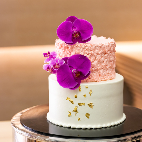 ウエディングケーキもオリジナルにこだわって。 存在感あるピンクの胡蝶蘭や、側面に金箔をほどこして、会場のコーディネートに合わせたモダンでおしゃれなウエディングケーキ。